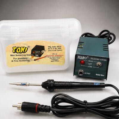 This is a Toni Mini Soldering Station, designed for jewellery and fine soldering tasks.It operates on 12V DC and features high/low power settings for variable heat control.The package includes a metal soldering station, a soldering pen, and a plastic container for storage.